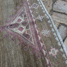Close-up of the pale pink vintage Turkish kars area rug showing traditional details, hand-knotted weave, wool and cotton and low pile.