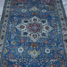 Close-up of the blue vintage Turkish kayseri rug showing floral details, hand-knotted weave, wool and cotton and low pile.