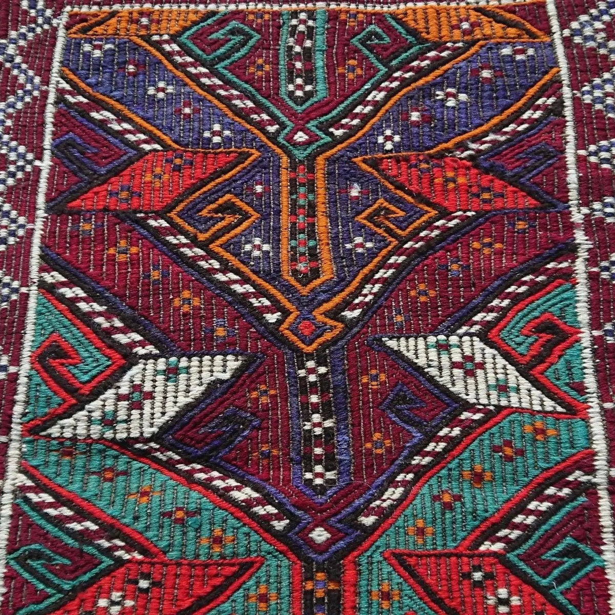 Close-up of the red vintage Turkish kilim rug showing traditional details, flatweave construction, wool and cotton and low pile.