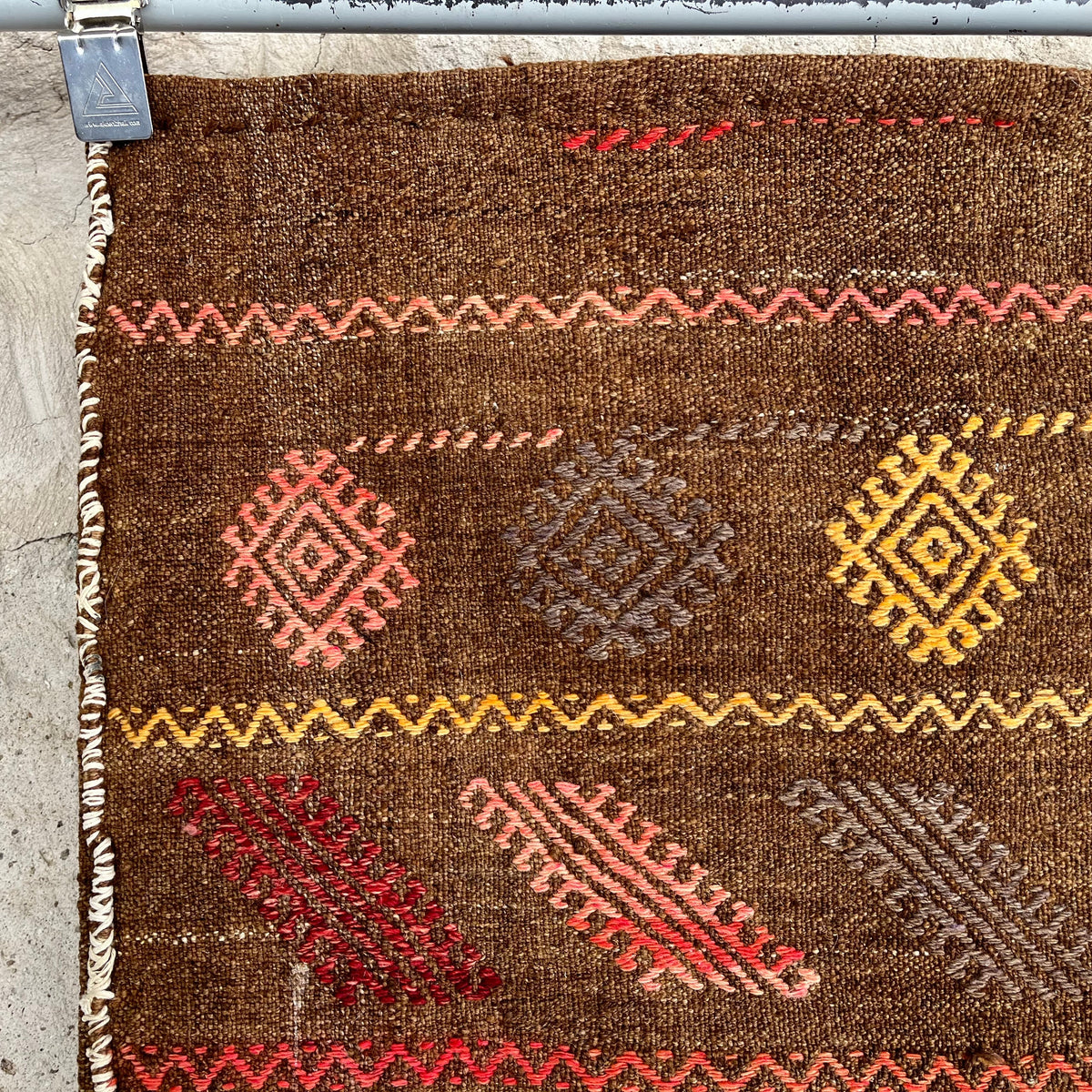 Brown 2' x 4' vintage Turkish kilim rug in wool and cotton, shown on the floor.