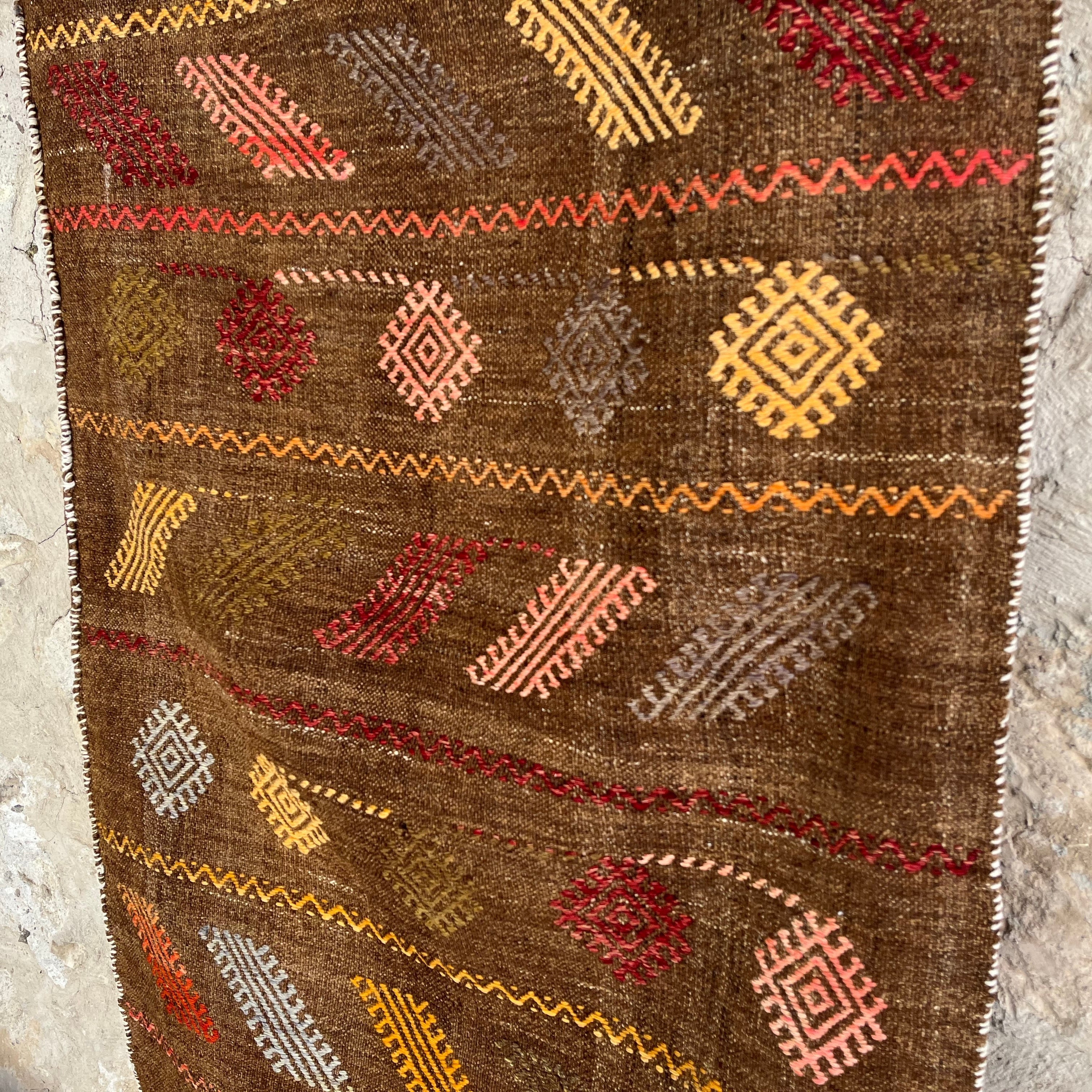 1970s brown vintage Turkish kilim rug with traditional design, flatweave construction and low pile.