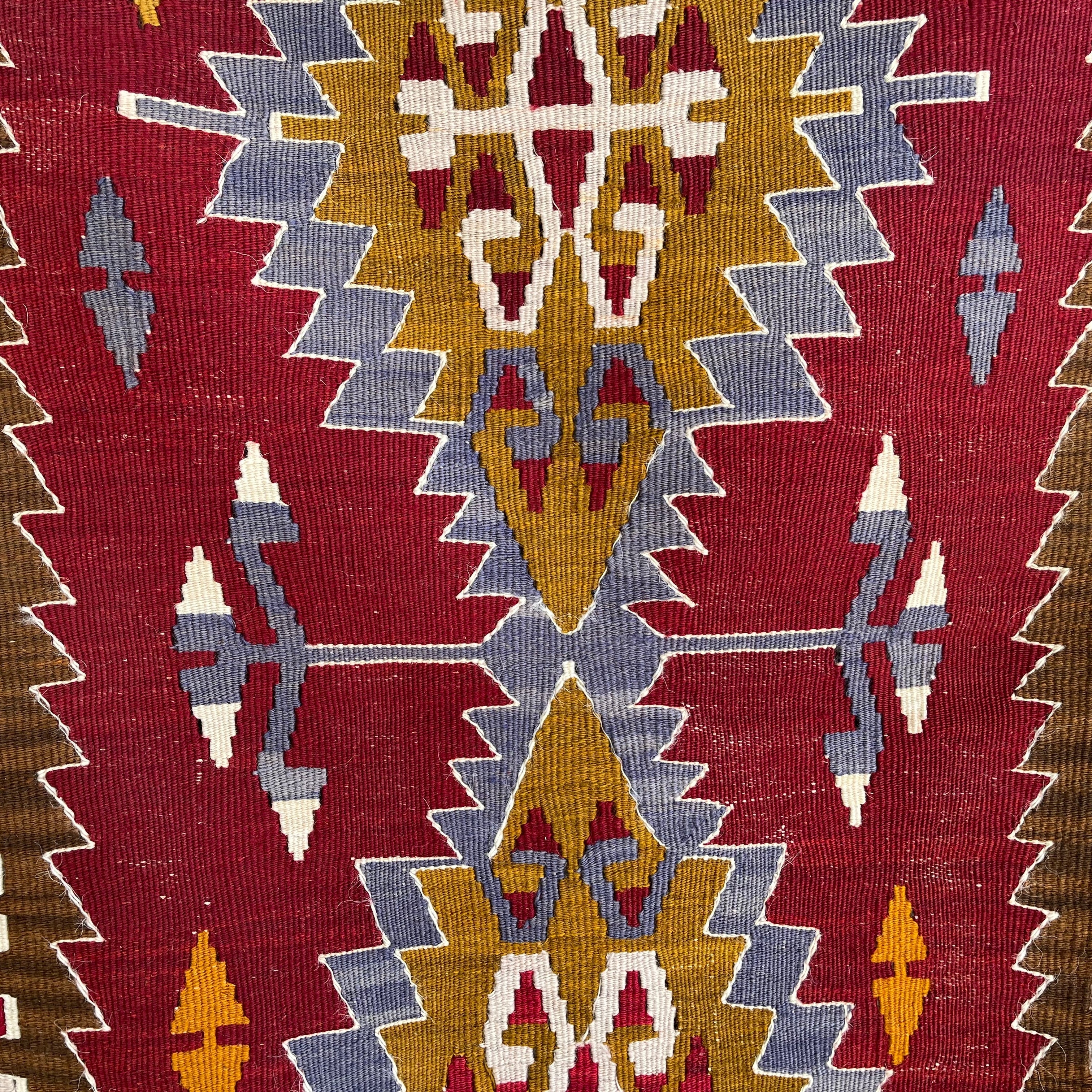 Red 2' x 4' vintage Turkish kilim rug in wool and cotton, shown on the floor.