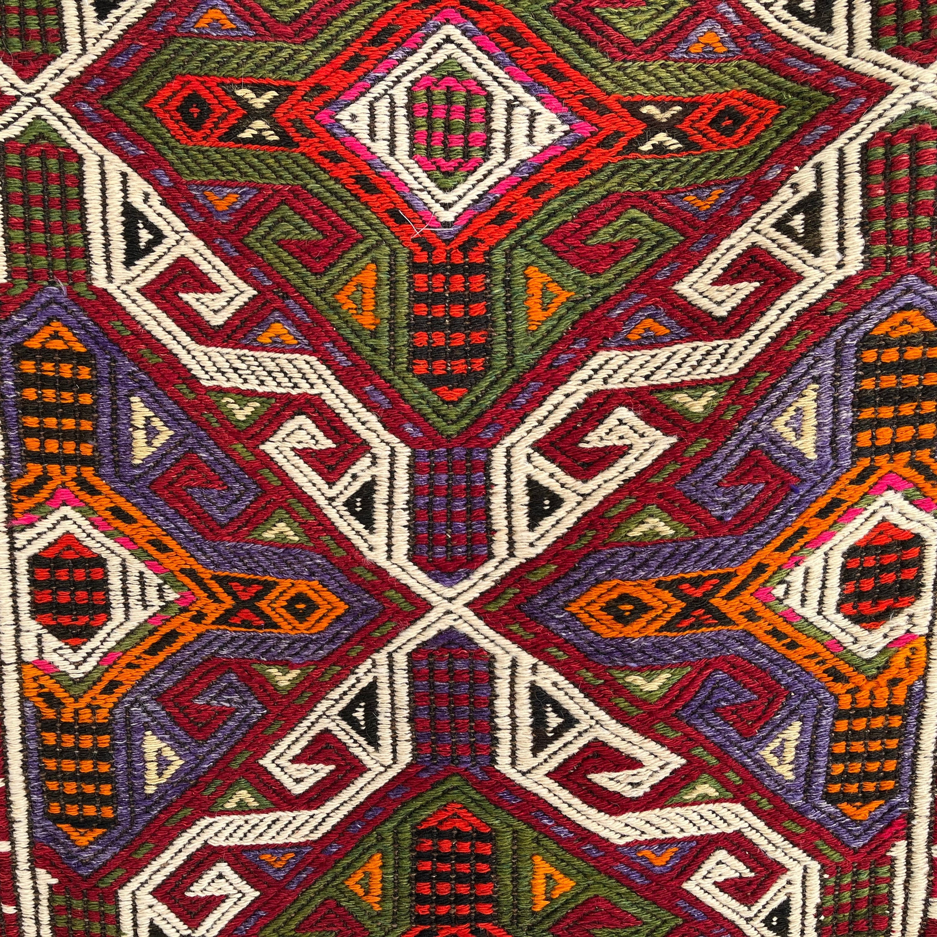 Close-up of the red vintage Turkish kilim rug showing traditional details, flatweave construction, wool and cotton and low pile.