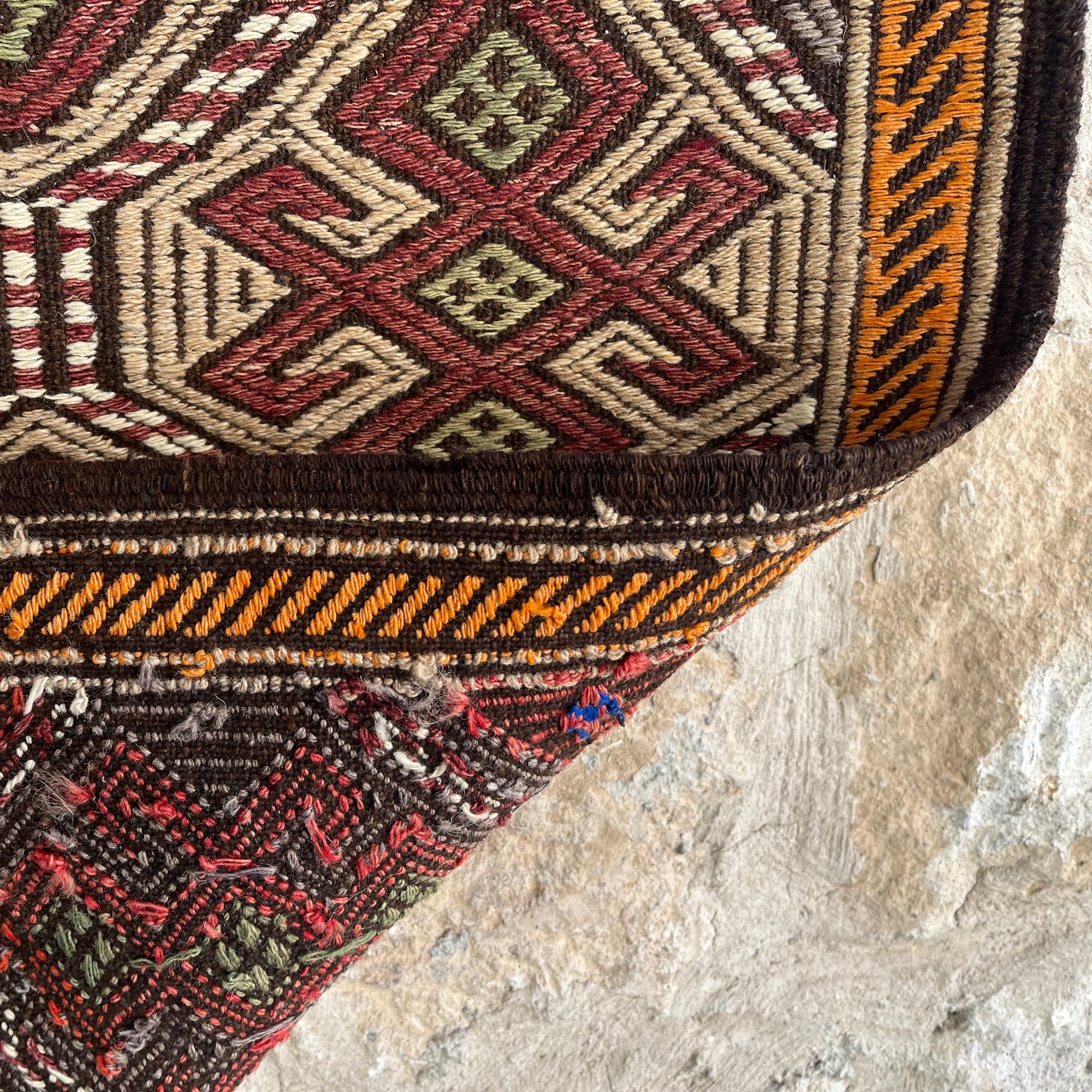 Close-up of the brown vintage Turkish kilim rug showing traditional details, flatweave construction, wool and cotton and low pile.