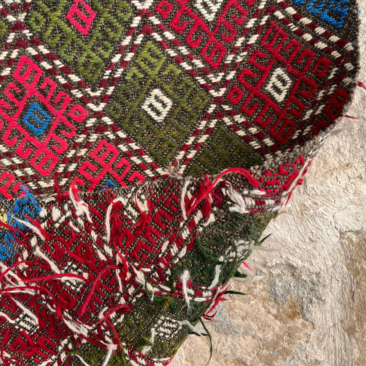 Close-up of the red vintage Turkish kilim rug showing traditional details, flatweave construction, wool and cotton and low pile.