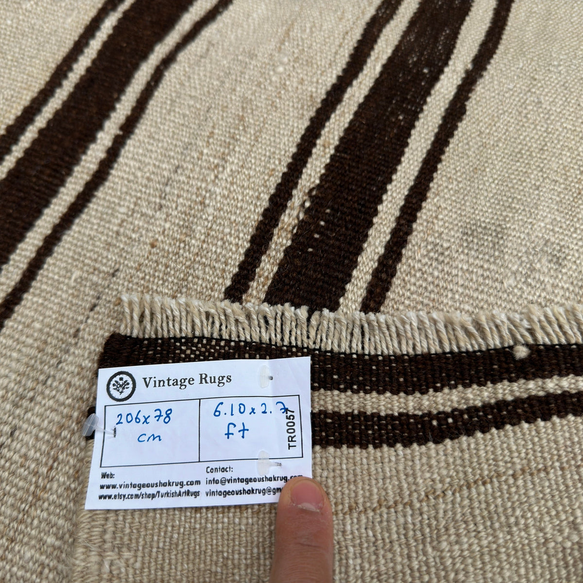 Close-up of the black vintage Turkish kilim rug showing striped details, flatweave construction, wool and cotton and low pile.