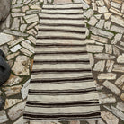 Black 3' x 7' vintage Turkish kilim rug in wool and cotton, shown on the floor.