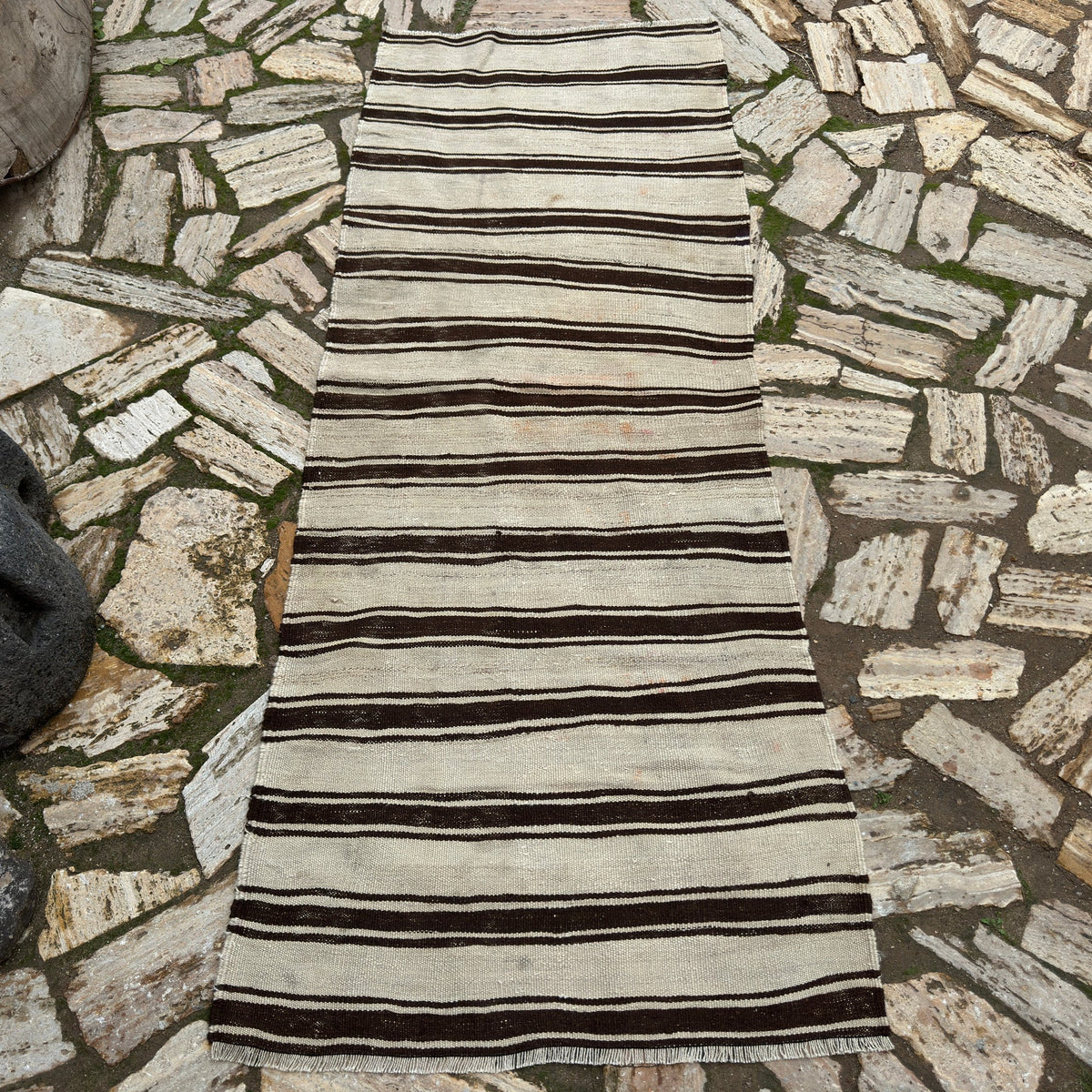 Black 3' x 7' vintage Turkish kilim rug in wool and cotton, shown on the floor.