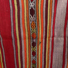 Close-up of the red vintage Turkish kilim rug showing striped details, flatweave construction, wool and cotton and low pile.