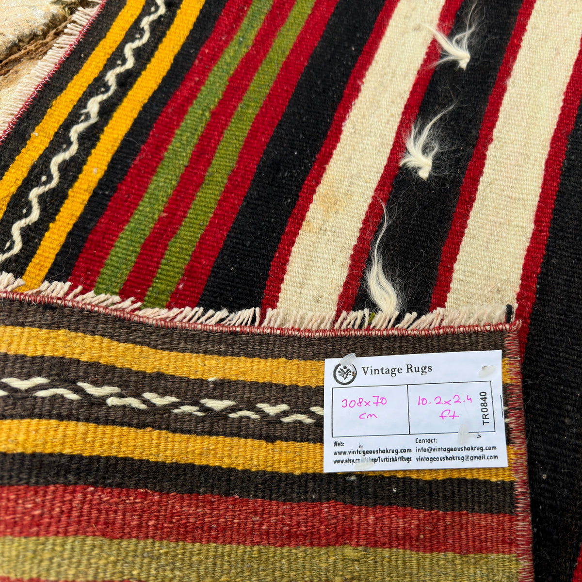 Close-up of the red vintage Turkish kilim runner rug showing striped details, flatweave construction, wool and cotton and low pile.