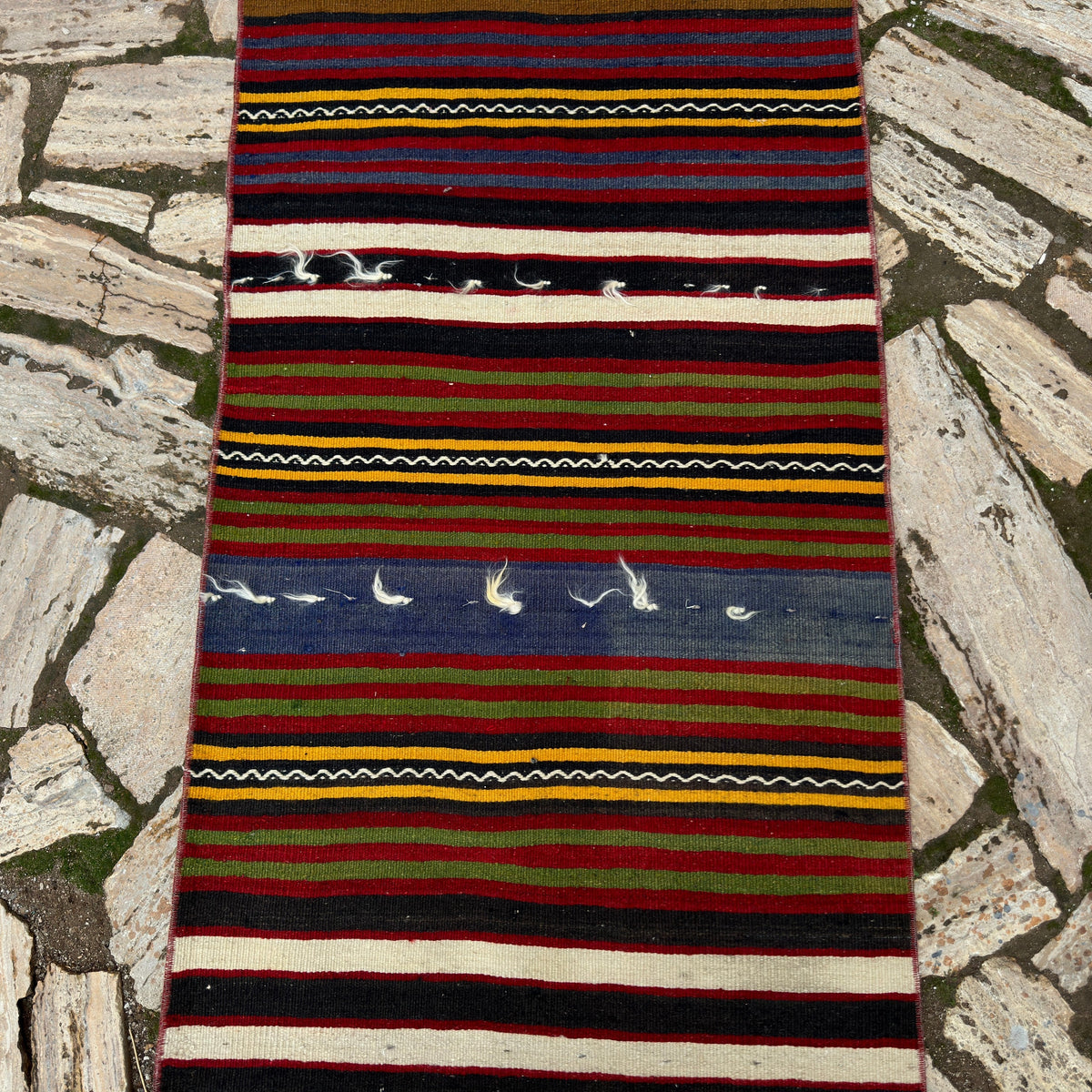 1970s red vintage Turkish kilim runner rug with striped design, flatweave construction and low pile.