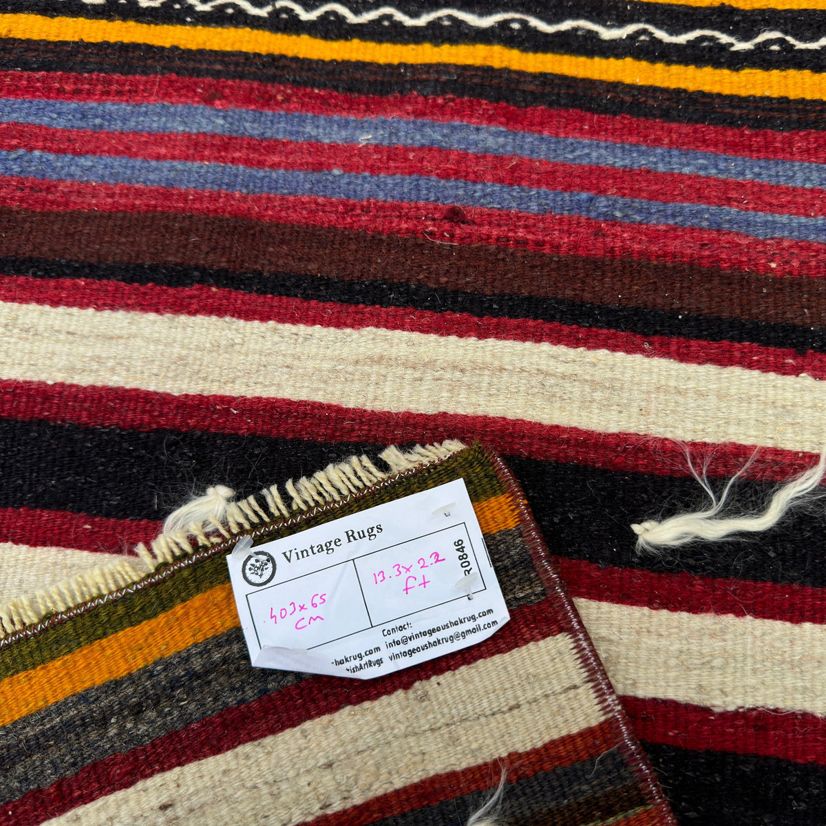 Close-up of the red vintage Turkish kilim runner rug showing striped details, flatweave construction, wool and cotton and low pile.