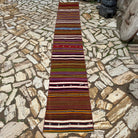 Red 2' x 13' vintage Turkish kilim runner rug in wool and cotton, shown on the floor.