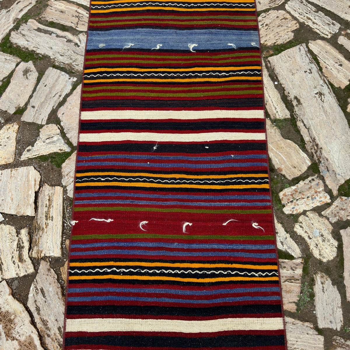 1970s red vintage Turkish kilim runner rug with striped design, flatweave construction and low pile.