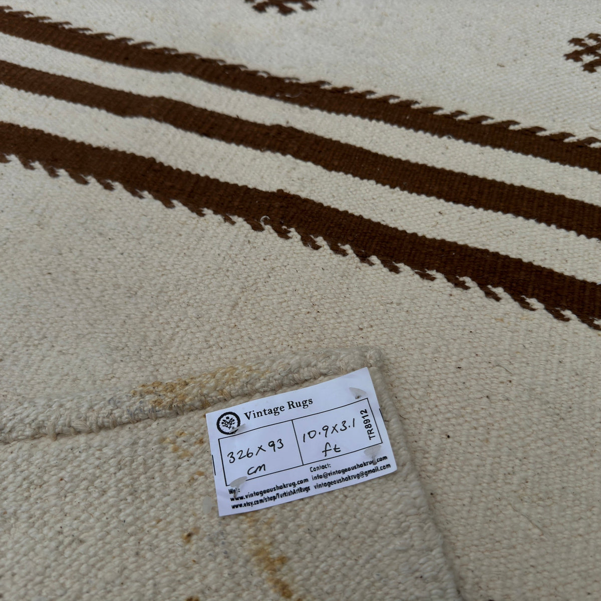 Close-up of the beige vintage Turkish kilim runner rug showing striped details, flatweave construction, wool and cotton and low pile.