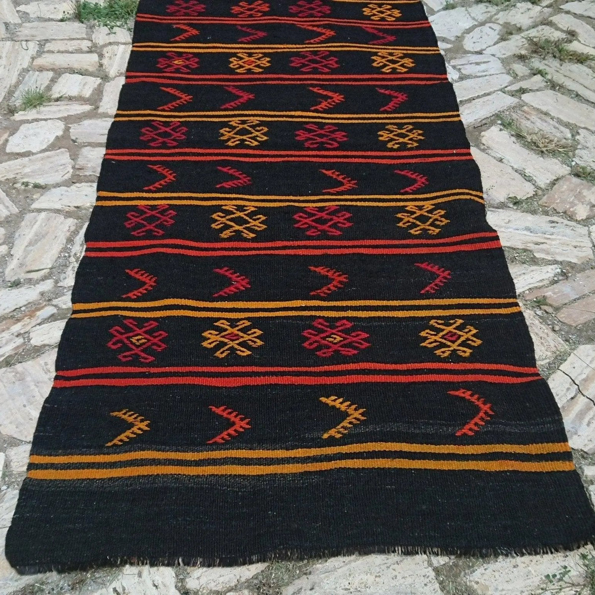 Black 3' x 11' vintage Turkish kilim runner rug in wool and cotton, shown on the floor.
