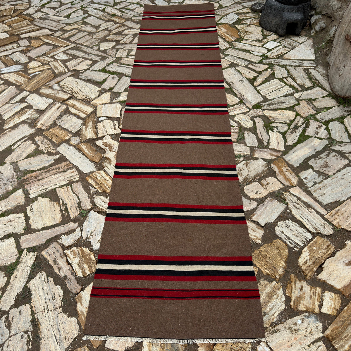 Brown 3' x 12' vintage Turkish kilim runner rug in wool and cotton, shown on the floor.