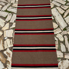 1970s brown vintage Turkish kilim runner rug with striped design, flatweave construction and low pile.