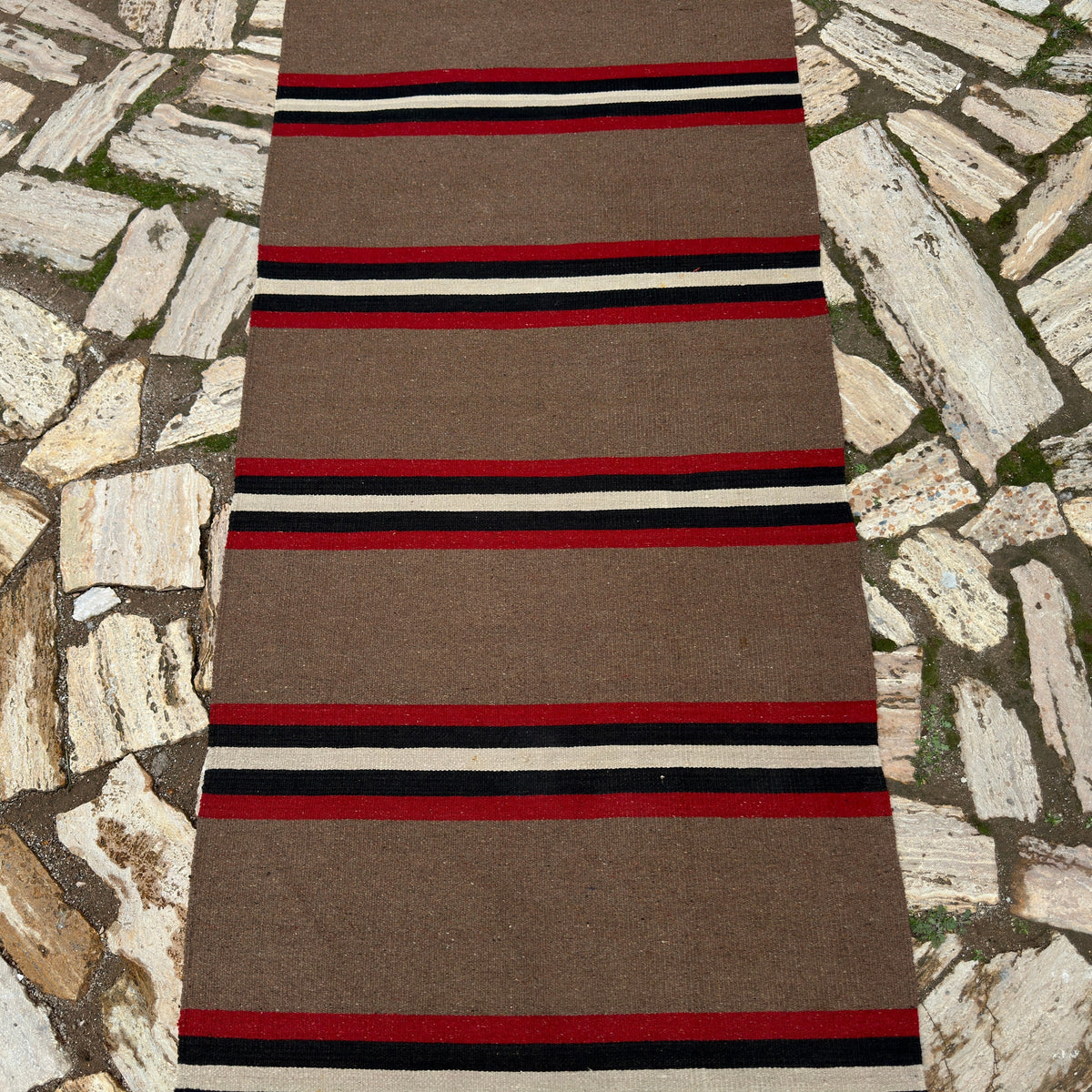 1970s brown vintage Turkish kilim runner rug with striped design, flatweave construction and low pile.