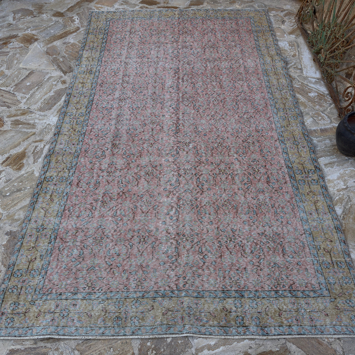 Pink 5' x 10' vintage Turkish large floral rug in wool and cotton, shown on the floor.