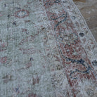 Close-up of the green vintage Turkish large floral rug showing floral details, hand-knotted weave, wool and cotton and low pile.
