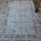 Green 8' x 11' vintage Turkish large floral rug in wool and cotton, shown on the floor.
