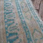 Close-up of the pale green vintage Turkish large rug showing traditional details, hand-knotted weave, wool and cotton and low pile.