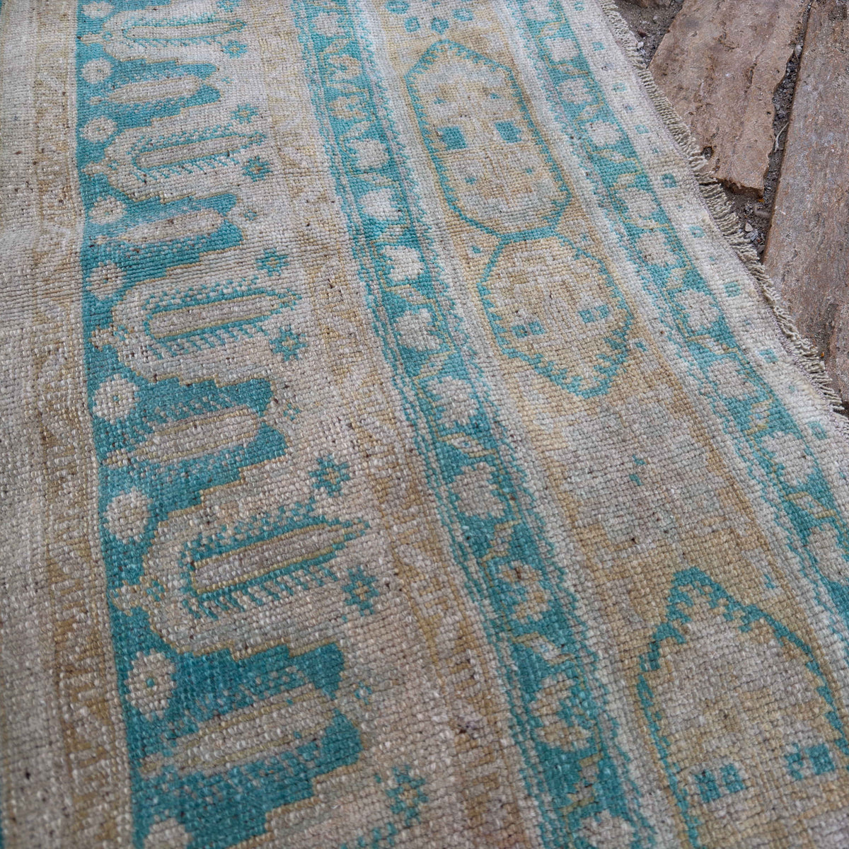 Close-up of the pale green vintage Turkish large rug showing traditional details, hand-knotted weave, wool and cotton and low pile.