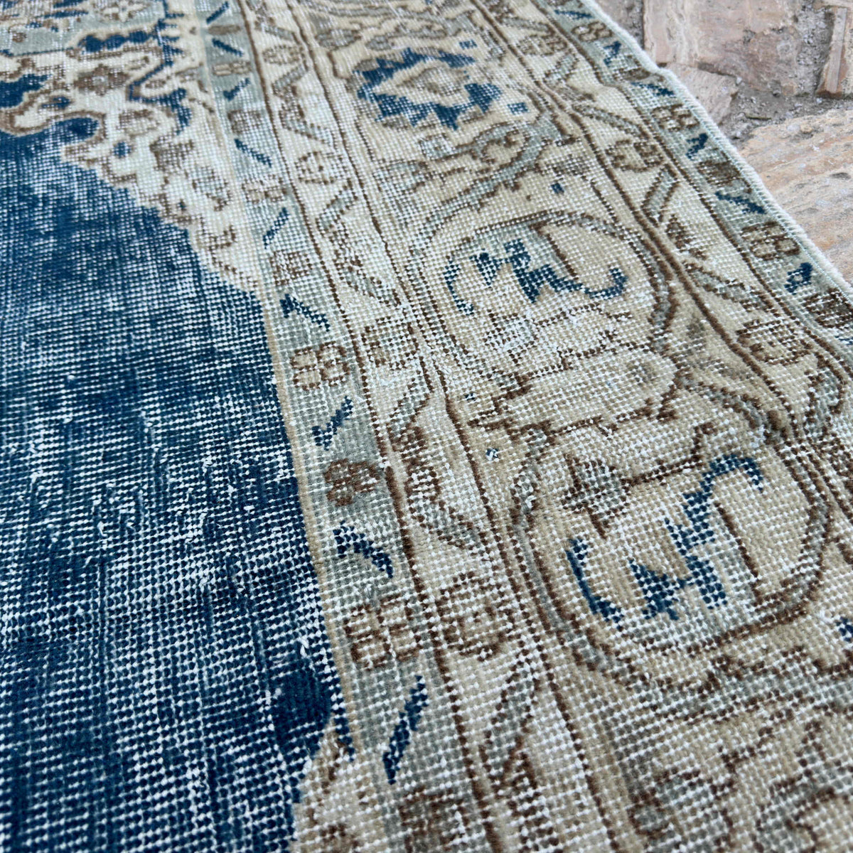 Close-up of the blue vintage Turkish large rug showing medallion details, hand-knotted weave, wool and cotton and low pile.