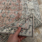 Close-up of the pale red vintage Turkish large rug showing floral details, hand-knotted weave, wool and cotton and low pile.