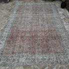 Pale Red 7' x 10' vintage Turkish large rug in wool and cotton, shown on the floor.