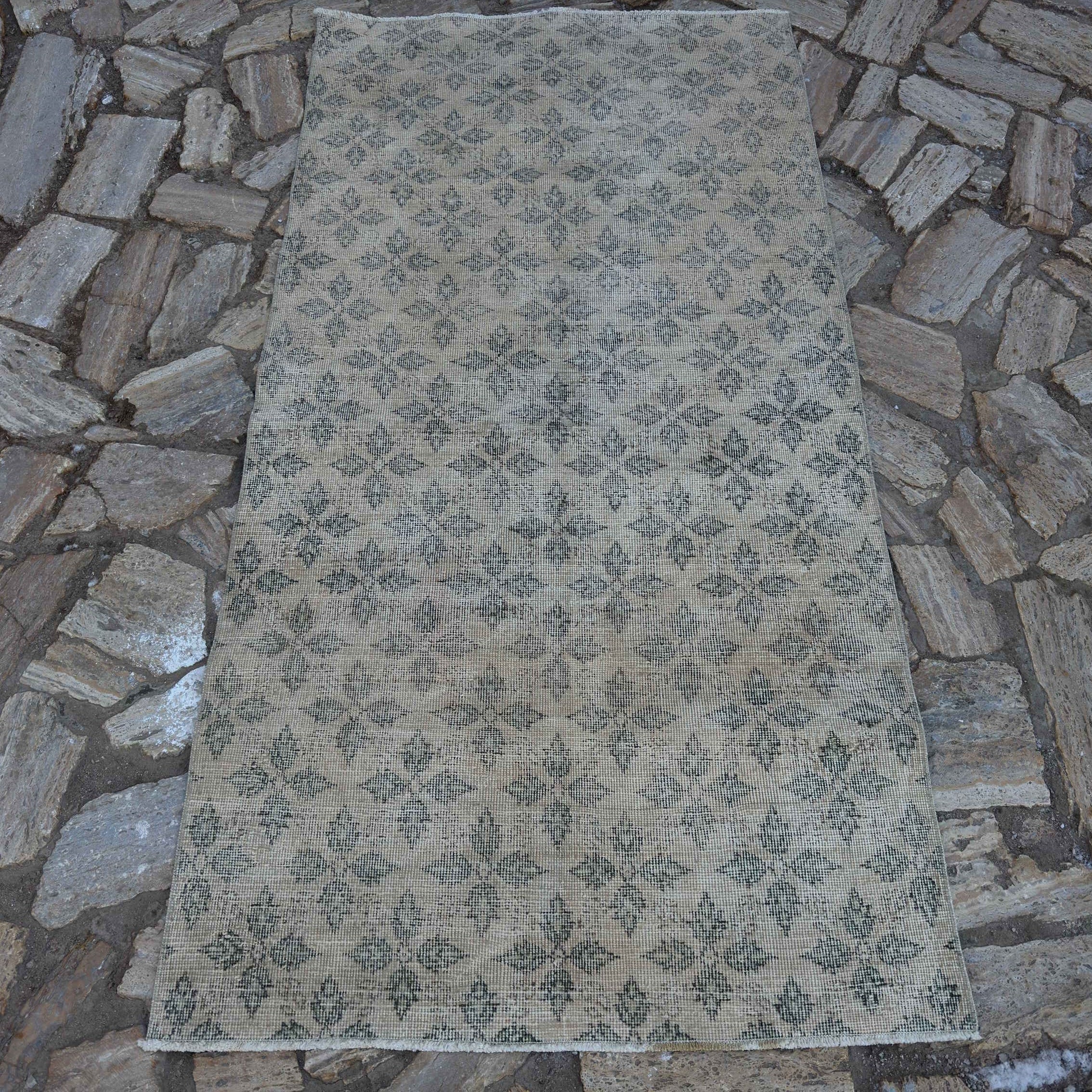 Beige 3' x 7' vintage Turkish low pile rug in wool and cotton, shown on the floor.