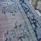 Close-up of the pale pink vintage Turkish medallion carpet showing medallion details, hand-knotted weave, wool and cotton and low pile.
