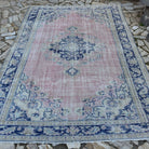 Pale Pink 7' x 10' vintage Turkish medallion carpet in wool and cotton, shown on the floor.