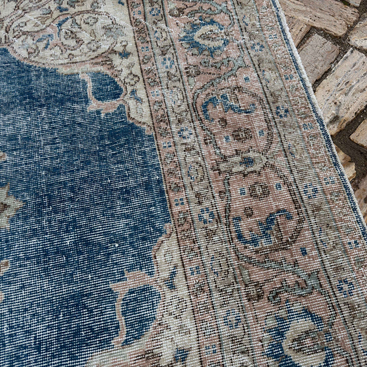 Close-up of the blue vintage Turkish medallion carpet showing medallion details, hand-knotted weave, wool and cotton and low pile.