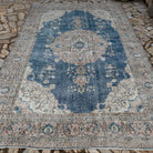 Blue 7' x 11' vintage Turkish medallion carpet in wool and cotton, shown on the floor.