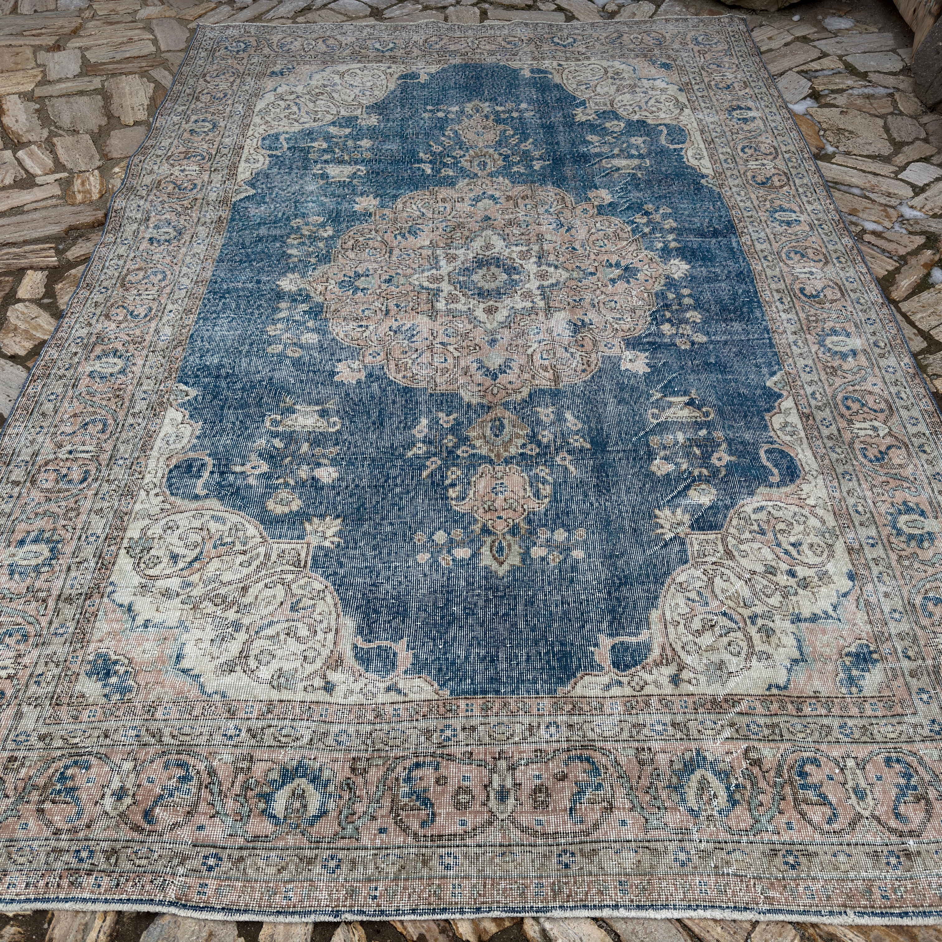 Blue 7' x 11' vintage Turkish medallion carpet in wool and cotton, shown on the floor.