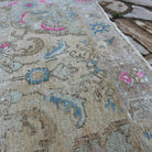 Close-up of the pink vintage Turkish medallion rug showing neutral details, hand-knotted weave, wool and cotton and low pile.