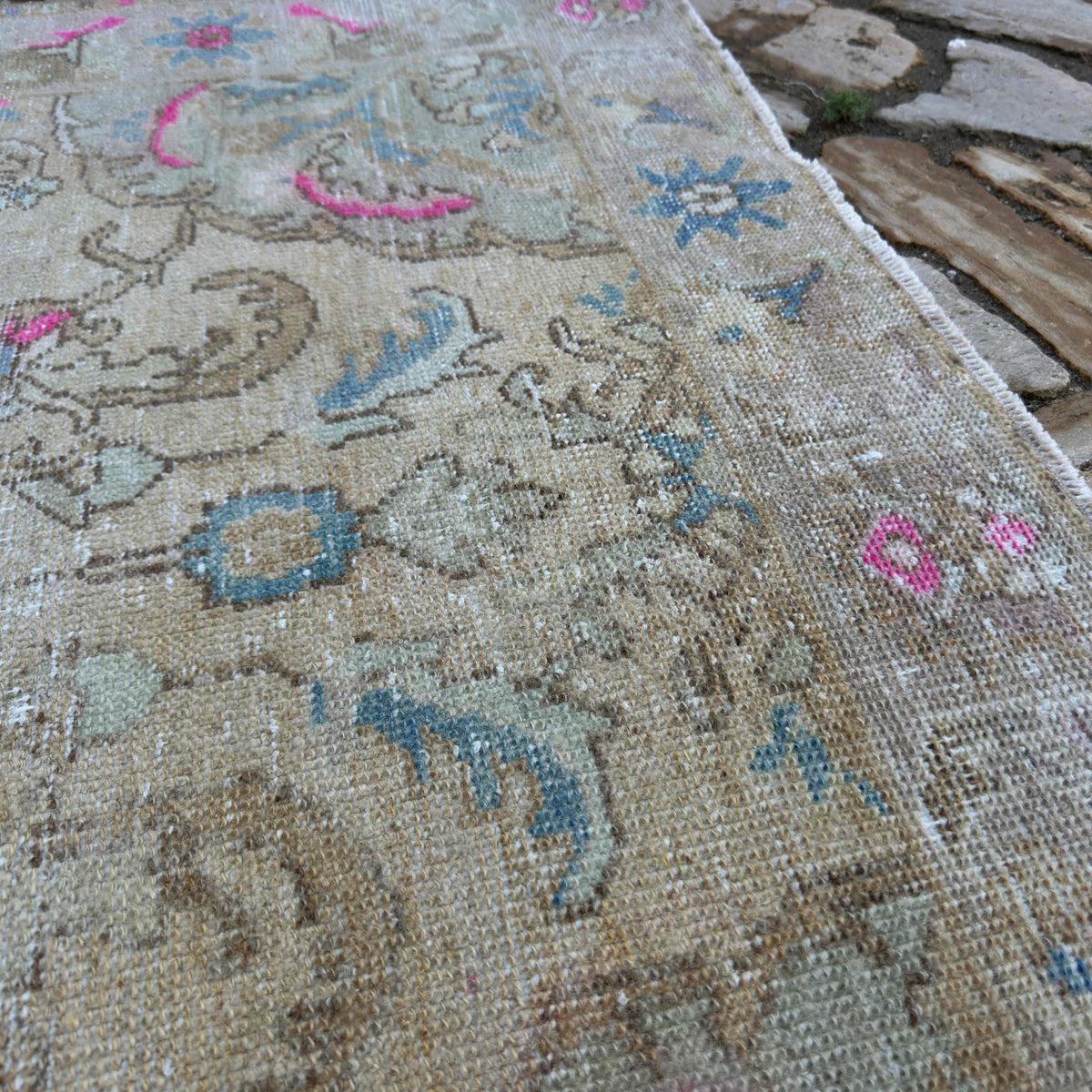 Close-up of the pink vintage Turkish medallion rug showing neutral details, hand-knotted weave, wool and cotton and low pile.