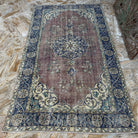 Close-up of the blue vintage Turkish medallion rug showing medallion details, hand-knotted weave, wool and cotton and low pile.