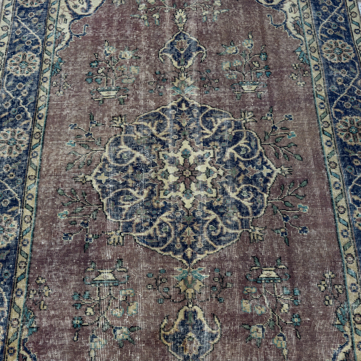 Blue 5' x 8' vintage Turkish medallion rug in wool and cotton, shown on the floor.