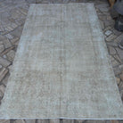 Beige 5' x 9' vintage Turkish medallion rug in wool and cotton, shown on the floor.