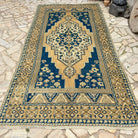 Blue 6' x 12' vintage Turkish medallion rug in wool and cotton, shown on the floor.