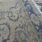 Close-up of the blue vintage Turkish medallion rug showing neutral details, hand-knotted weave, wool and cotton and low pile.