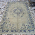 Blue 6' x 9' vintage Turkish medallion rug in wool and cotton, shown on the floor.