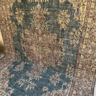 Blue 7' x 10' vintage Turkish medallion rug in wool and cotton, shown on the floor.