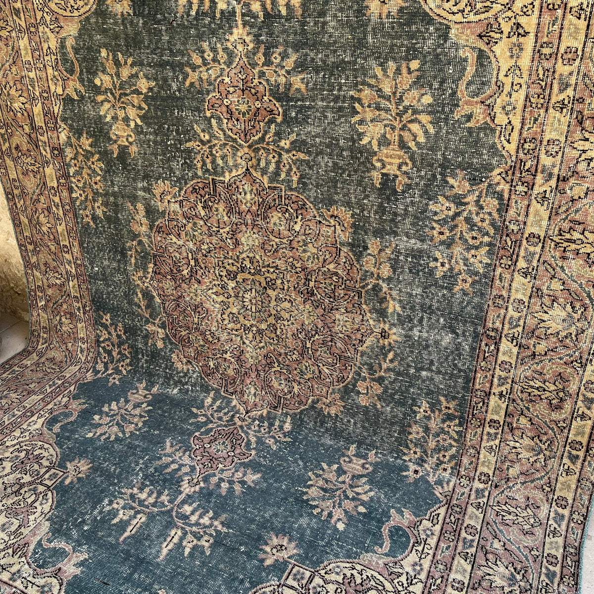 Blue 7' x 10' vintage Turkish medallion rug in wool and cotton, shown on the floor.
