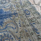 Close-up of the blue vintage Turkish medallion rug showing medallion details, hand-knotted weave, wool and cotton and low pile.