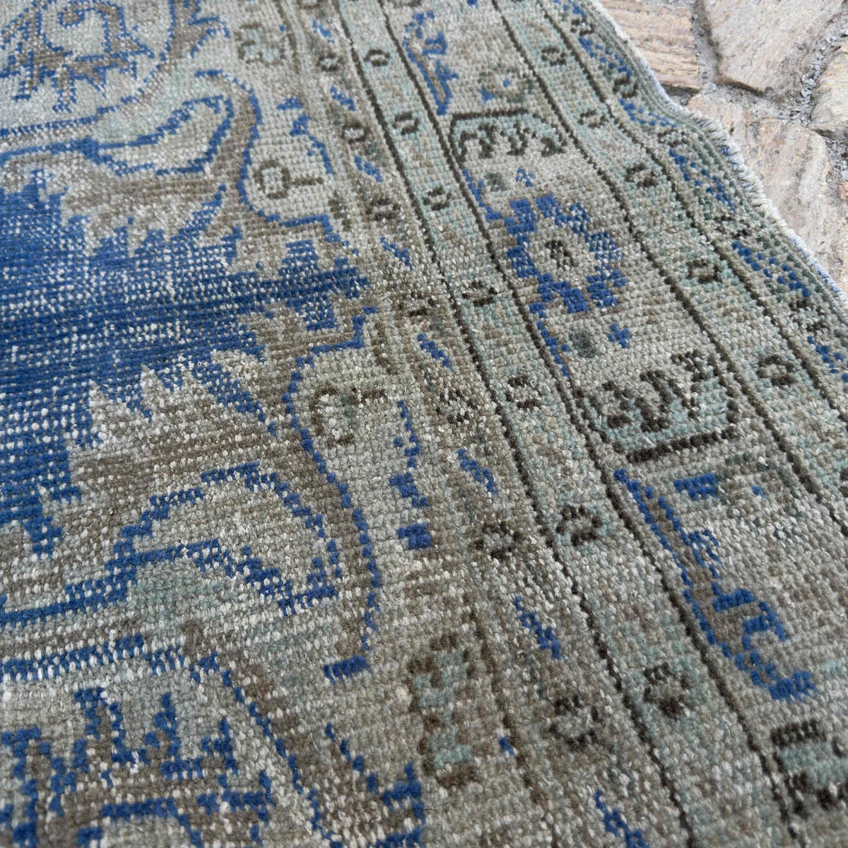 Close-up of the blue vintage Turkish medallion rug showing medallion details, hand-knotted weave, wool and cotton and low pile.