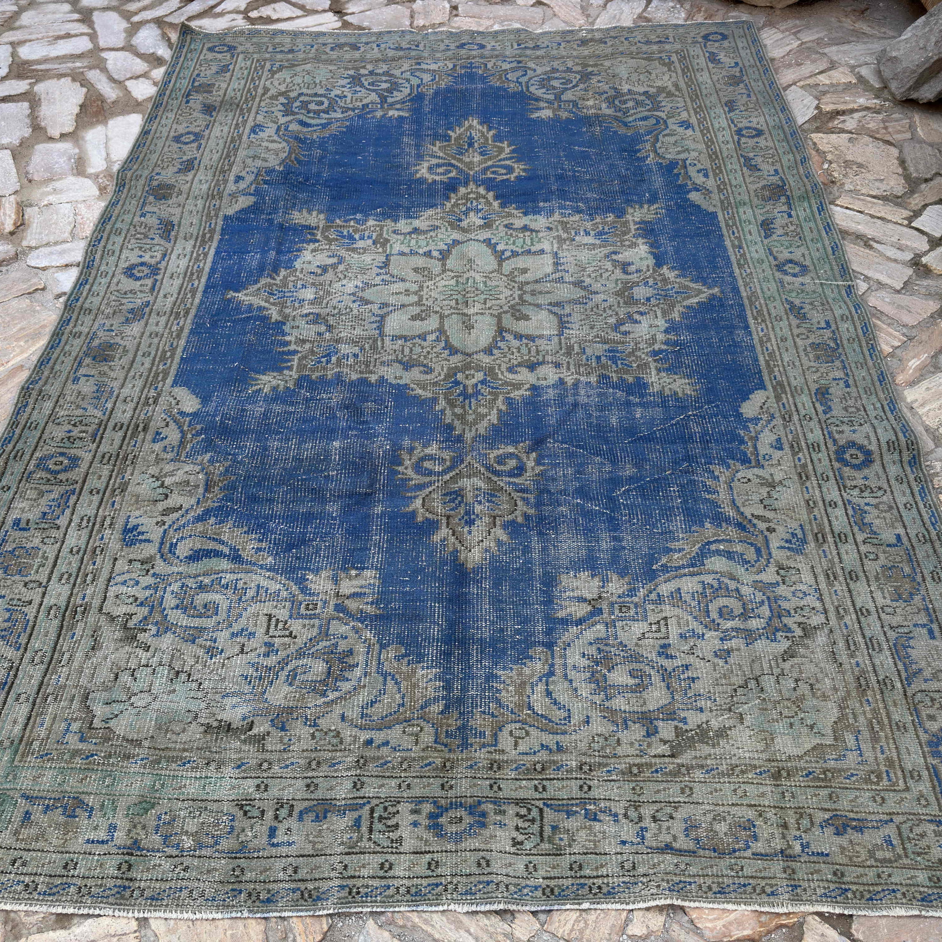 Blue 7' x 10' vintage Turkish medallion rug in wool and cotton, shown on the floor.